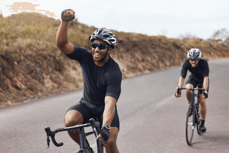 Homens pedalam juntos em uma estrada tranquila, aproveitando um dia ensolarado. 