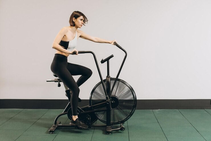 Mulher treinando na sua air bike.