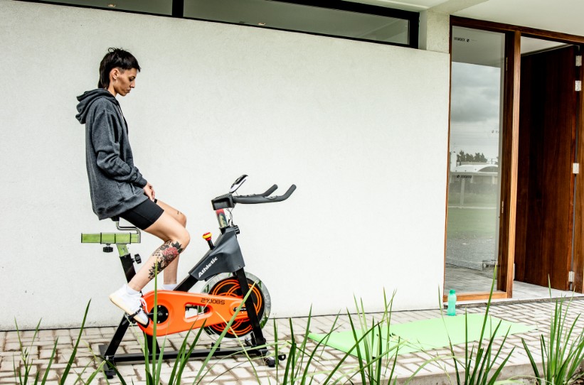 Mulher se exercitando em uma bicicleta ergométrica. 