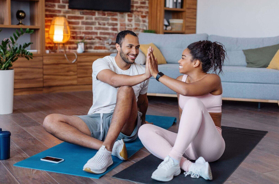 Casal feliz após realizar treino funcional para casais em casa.