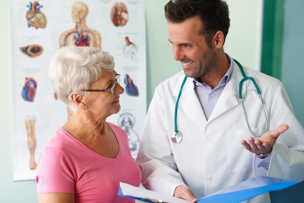 Médico explicando à uma senhora a a importância da saúde do coração para a longevidade